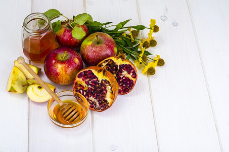 罗什Roshhashhanah犹太节日概念木制天线上的蜂蜜苹果和石榴工作室照片木制天线上的蜂蜜苹果和石榴背景