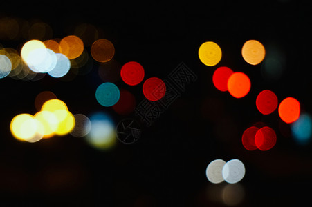 夜里在城市街道上闪亮的彩色抽象bokeh灯光背景图片