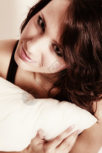 黑身的感懒惰女孩抱着枕头在床上背景图片