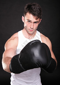 拳手举起他的臂强壮运动肌肉男子体育展示他的肌肉男背部与黑人景隔绝图片