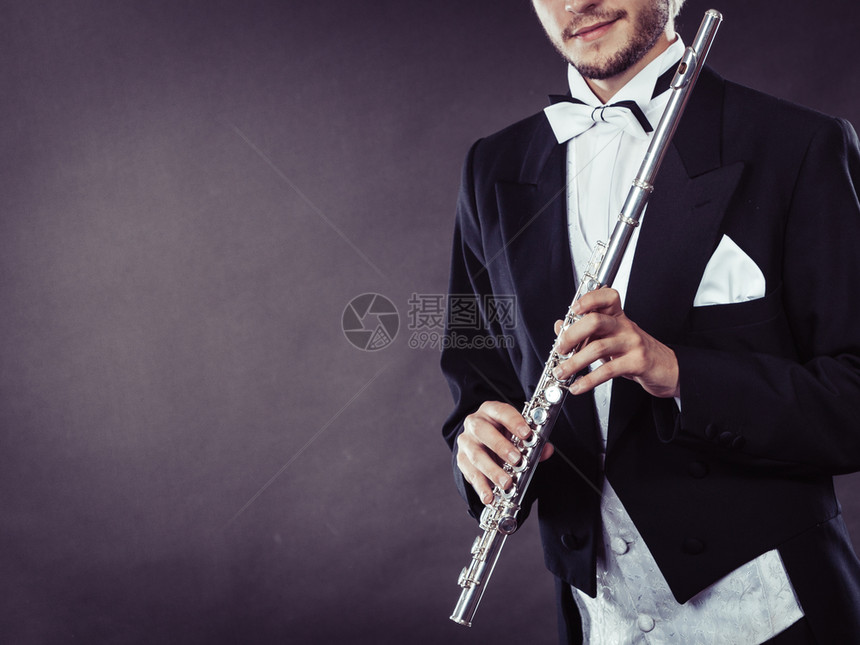 古典音乐激情和业余爱好概念穿着优美服装的音乐人持长笛深底背景摄影棚拍图片