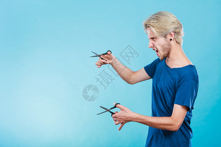 感的男理发师拿着剪刀显示工作具正常和剪背景图片