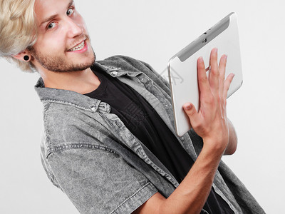 教育社会媒体现代技术互联网概念使用平板电脑的时尚英俊男青年使用平板电脑的特伦迪青年男子背景图片