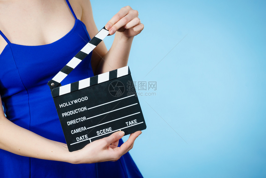 拥有专业电影板拍好莱坞生产目标概念蓝背景摄影棚专业电板的妇女图片