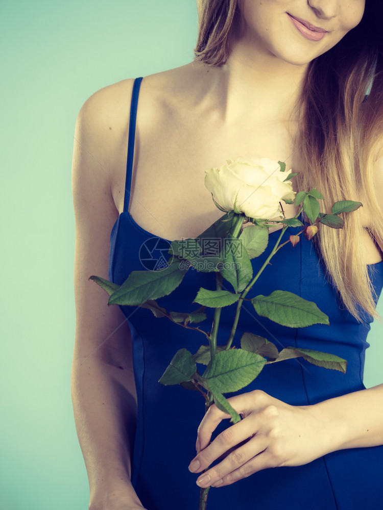 手握白玫瑰花的年轻女子情人节和妇女礼物概念手握白玫瑰的女子图片