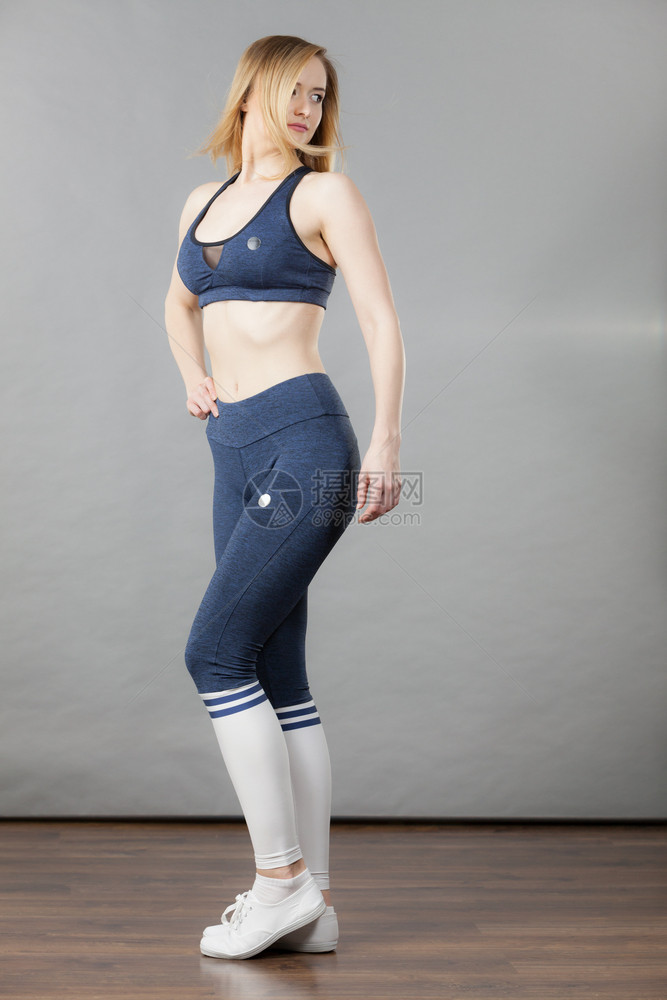 穿着运动服蓝胸罩长腿袜子和训练员的妇女图片