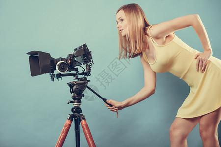 摄影女师拍图片有吸引力的时尚髦金发女郎拍摄相机蓝背景照片图片