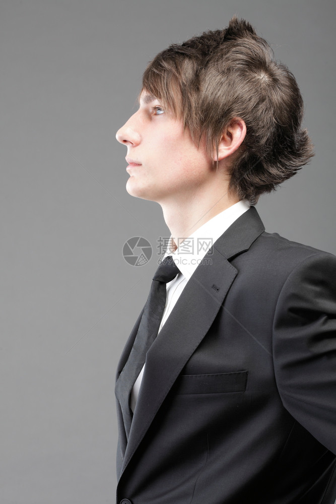 时装年轻商人黑西灰色背景的散衣领带图片