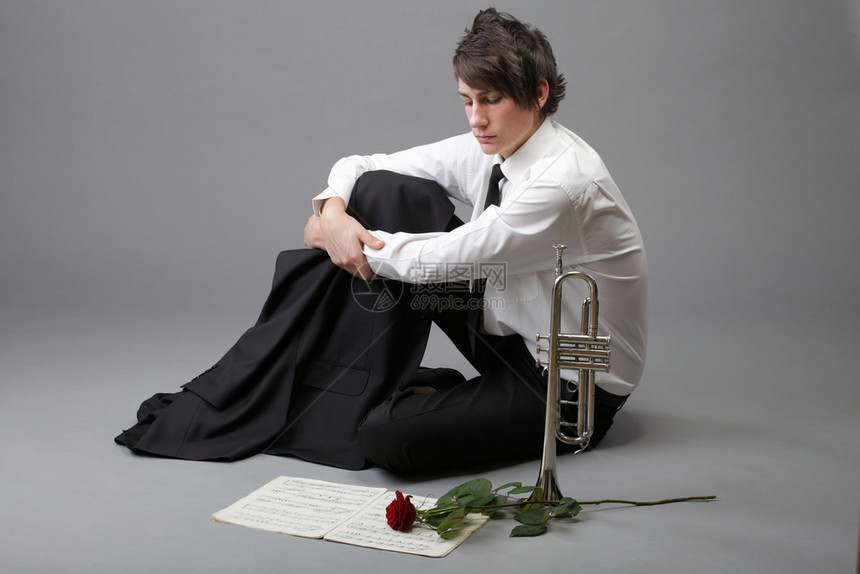 一个年轻的爵士人和Trumpet灰色背景的肖像爱情旋律图片