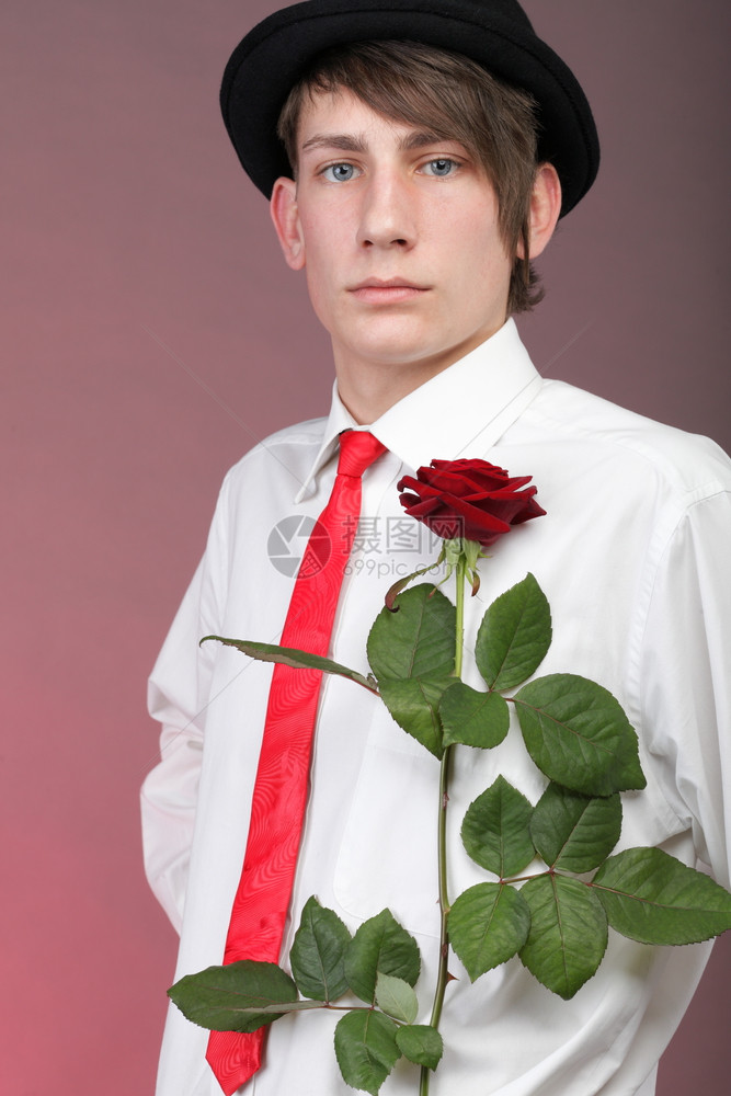 有红玫瑰的年轻人穿着彩色背景爱与反射图片