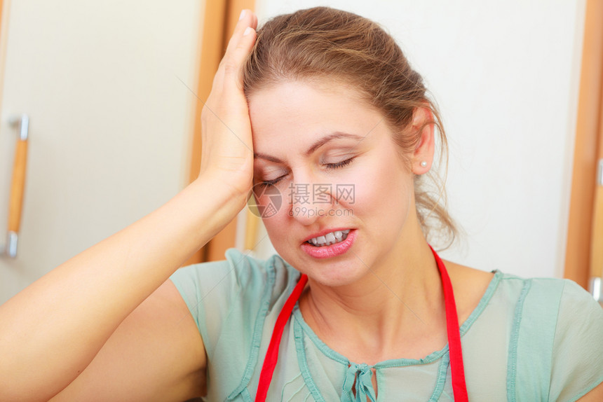 患有头痛偏的女年长者在厨房有压力的女年长者患有头痛的女年长者患有头痛偏的女年长者患有头痛的女年长者图片