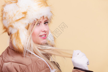 时装概念寒冷穿衣服的套件冬金发女人穿着俄罗斯风格的暖毛帽图片