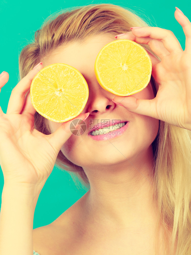 女少手里握着两半黄柠檬柑橘水果遮住眼睛涂着绿色健康饮食营养幸福快乐概念女孩用柠檬柑橘水果蒙住眼睛图片