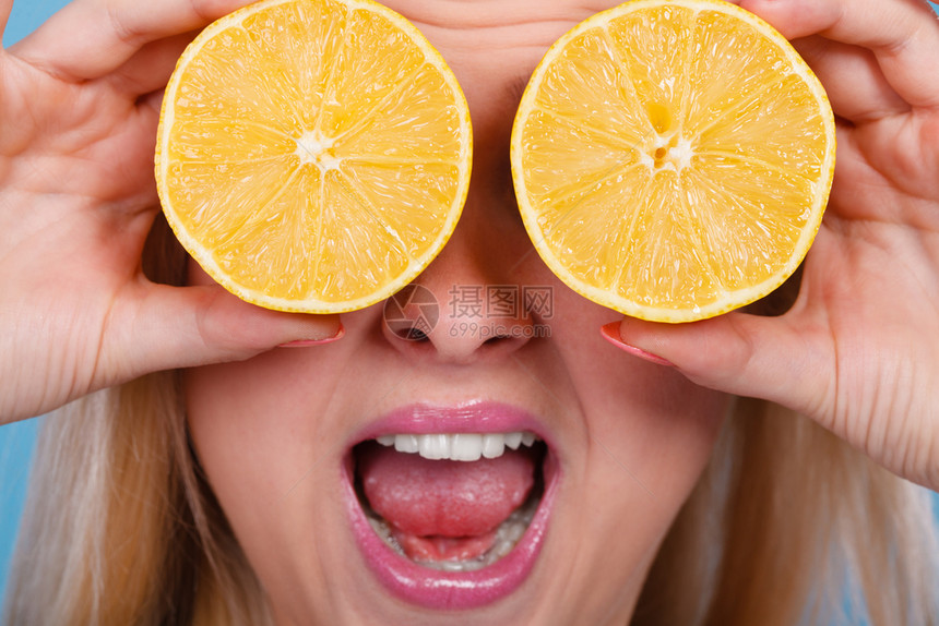 健康饮食新鲜物充满维他命女人拿着甜的柑橘水果柠檬两半假装是眼镜女人拿着水果柠檬一半在眼睛上图片