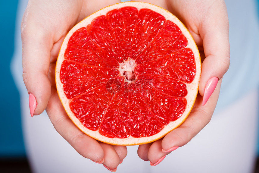 红葡萄油柑橘水果的一半放在女手上健康饮食体重丧失概念红葡萄油柑橘水果的一半放在人类手中图片