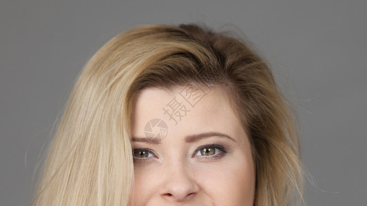 金发女人半脸鼻子和绿眼睛演播室在灰色背景中拍摄女人半脸鼻子和眼睛图片