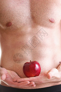 感肌肉湿青年男子躯干和红苹果在手的饮食图片