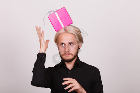 头顶有粉红色礼品盒的男人背景图片