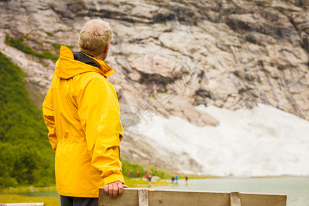 旅行概念游者在挪威的岩石雪山景色上仰望着挪威的山地景象图片