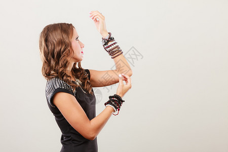 身戴多条手镯首饰项链的年轻美女背景图片