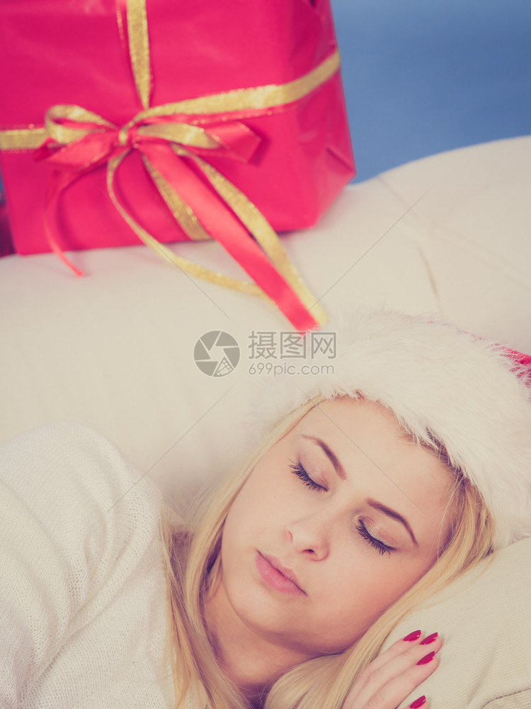 圣诞期待休闲和放松概念睡在沙发上等待礼物的圣诞妇女睡在沙发上的圣诞妇女图片