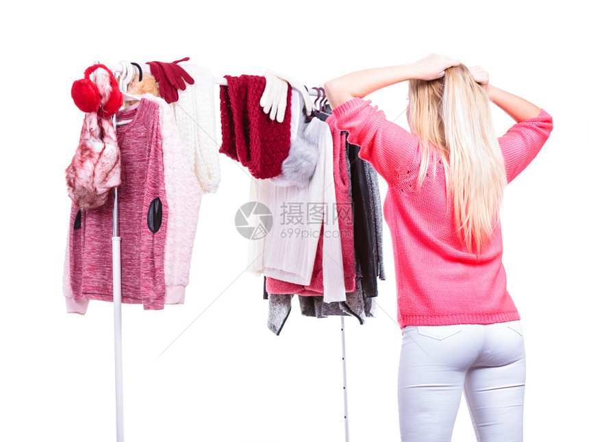 年轻女站在衣柜或商场选择温暖的衣服决定穿什么衣服或买选择冬季秋天服装概念后视图片