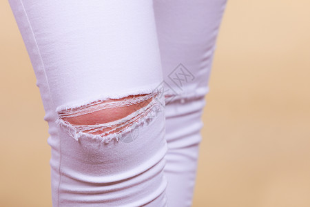 白色裤子时装和当前趋势概念详细缝紧白妇女裤子膝上穿洞缝紧白妇女裤子膝上穿洞背景