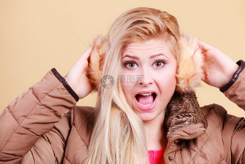时装概念穿着冬暖耳罩和外套的金发女人穿冬耳罩和外套的金发女人图片