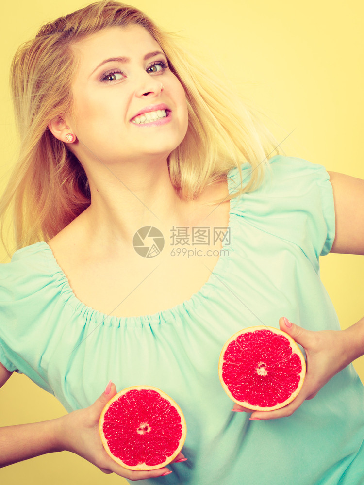 健康饮食充满维生素的新鲜食物快乐的疯女人拿着甜美的柑橘水果胸上红葡萄油在胸上图片