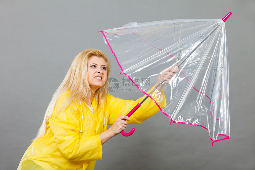 夏雨秋天的首饰思想概念有严肃面部表情的妇女打开清晰透明的伞与风作斗争图片