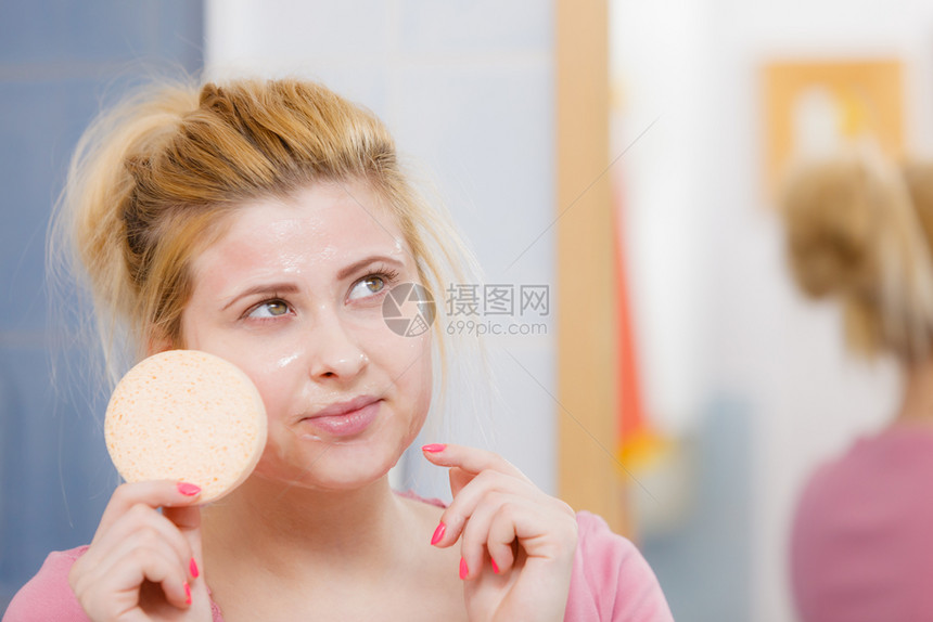 女在脸上洗凝胶手持海绵准备清洗皮肤女在脸上洗凝胶手持海绵图片