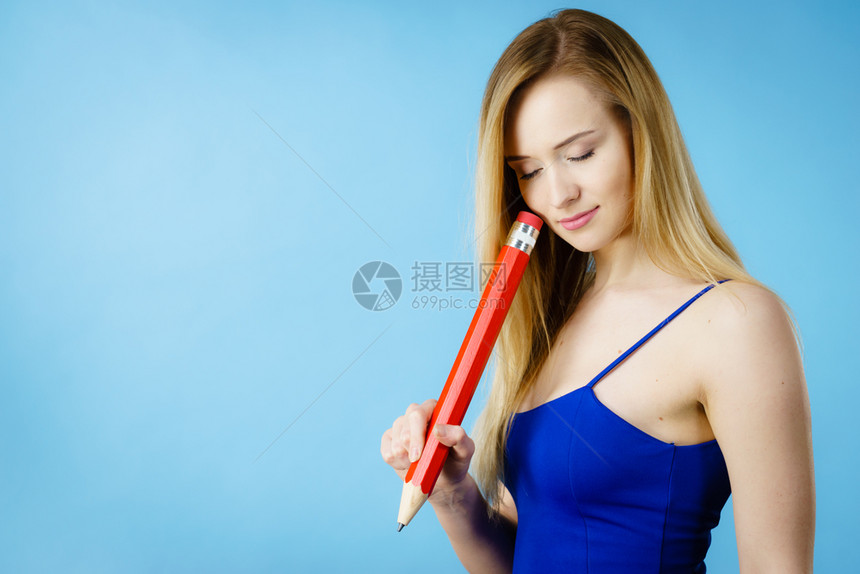 沉迷于思考的女人想寻求解决办法深思熟虑的女学生或提出一个想法持有大红铅笔工作室拍摄蓝色女困惑思考手头拿着大铅笔图片