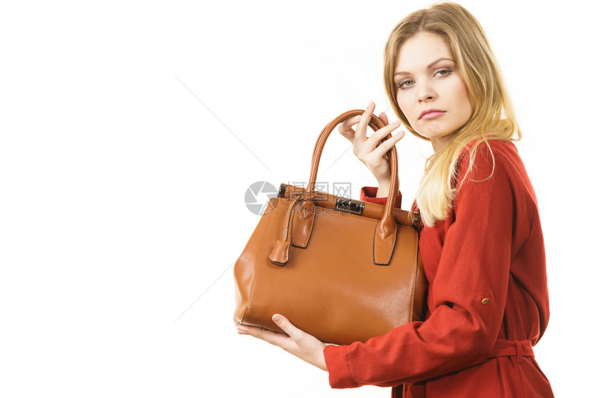 妇女保护她的手提包不受盗贼的伤害年轻女保护昂贵的皮包女保护她的手提包图片