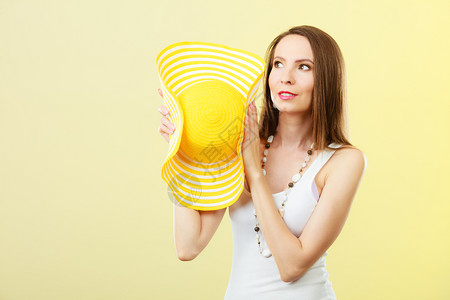 暑假时装和头部保护戴大黄帽子的女人光辉背景的迷人女肖像图片