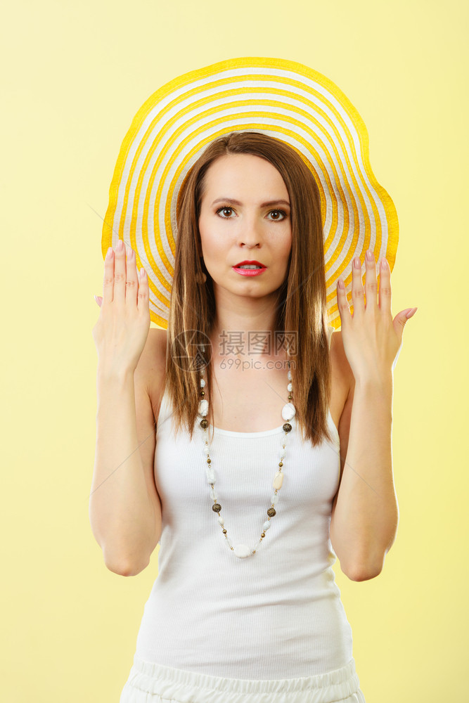 暑假时装和头部保护戴大黄帽子的女人光辉背景的迷人女肖像图片