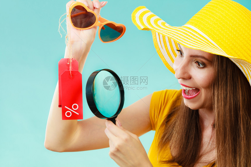 时装女选择太阳镜通过放大玻璃搜索贴红色标签手头有百分数符号图片