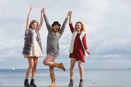 三位时尚女在海边展示时髦的服装风格时尚友谊概念三位时尚女在海上图片