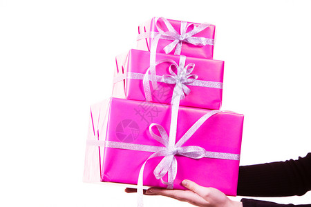 持有大堆礼物粉红盒和白丝带的人图片