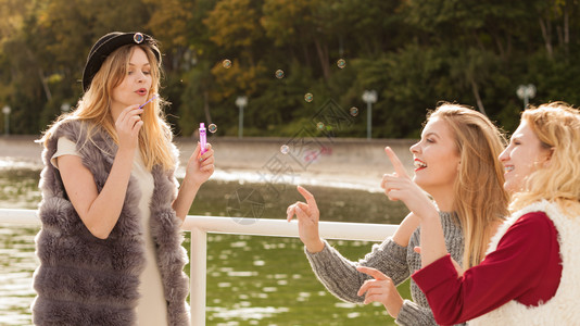 节日快乐友情概念女朋在户外玩吹肥皂泡的乐趣妇女一起吹肥皂泡的乐趣图片