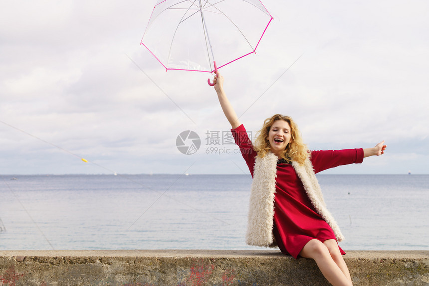 快乐的优雅成年女拿着透明的伞对天空气预报概念快乐的女士拿着伞图片