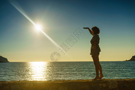 旅游概念在海上的旅游妇女享受自然的美丽日落图片