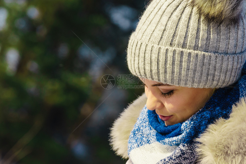 女在冬天穿着温暖的服装女穿着灰色的豆热帽有蓬和蓝色围巾图片