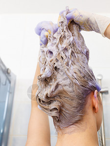 女在头发上涂彩色洗水女有紫色洗发制品在家里染金色女在头发上涂彩色洗水图片