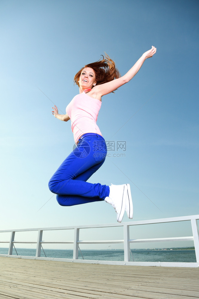 年轻女孩在天空中跳跃图片