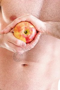 感肌肉湿青年男子躯干和红苹果在手的饮食图片