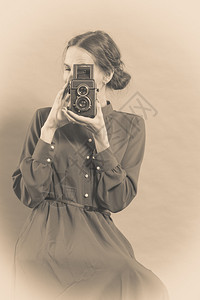 女古老风格长的深色礼服用旧相机照古老的片西普亚语调背景图片