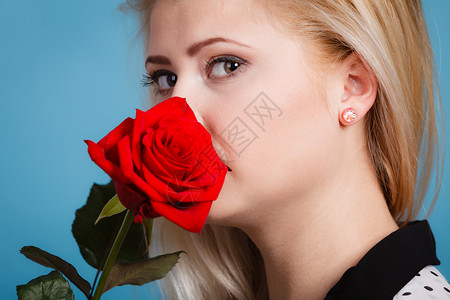 美丽可爱的女士拿着红玫瑰花美丽的年轻女士浪漫肖像背景图片