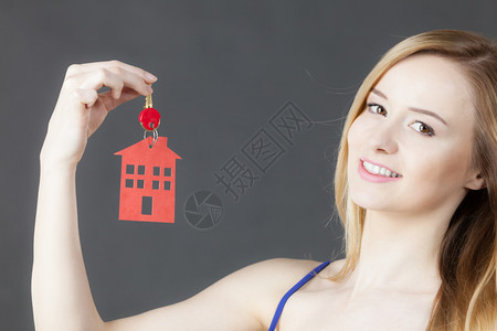 持有新房钥匙红色家庭形状不动产和住房概念背景图片