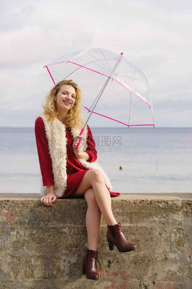 快乐的优雅成年女拿着透明的伞对天空气预报概念快乐的女士拿着伞图片