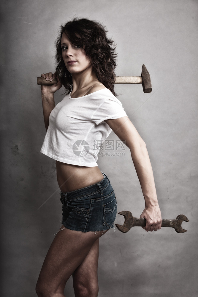平等和女权主义感孩拿着锤子和扳手打工具有吸引力的女修理工图片